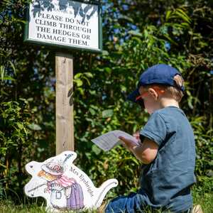 Child reading in front of a sign of Mrs Eyebright.